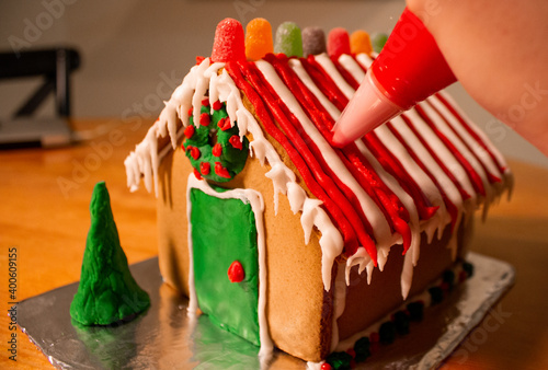 Gingerbread house on wood table being decorated