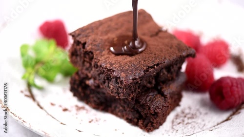 Pouring chocolate on brownies choolate cake. Sweet chocolate pastry photo