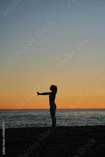 young spanish girl doing exercise in front of the mediterranean sea at sunset © Miguel Moebius