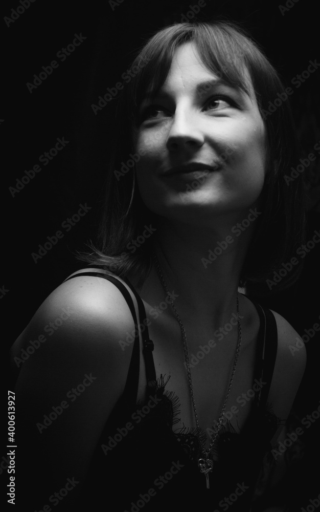 Девушка позирующая на черном фоне , черно белая фотография.

