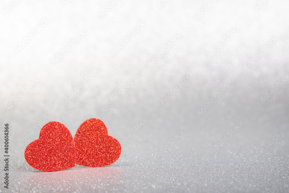 Fototapeta premium two red hearts in glitter on a silver glitter background