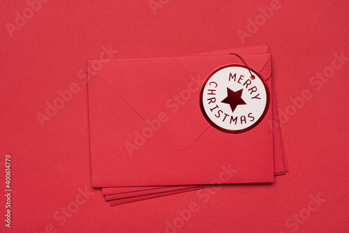 Stack of envelopes for santa concept. Top above overhead close up view photo of heap of red envelopes with tag isolated red background