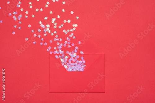 Top close up overhead view photo of open envelope and glitter decoration explosion white small mini snowflakes isolated bright table backdrop