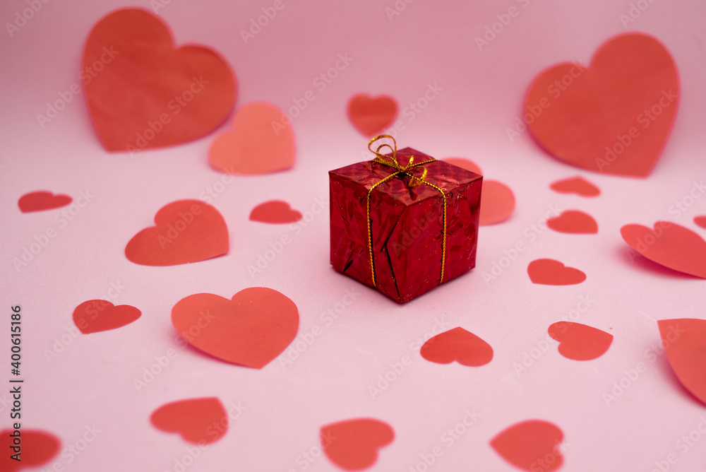 Red gift box and red hearts on a pink background. Valentine's day gift. Red gift box and red hearts on a pink background. Valentine's day gift.