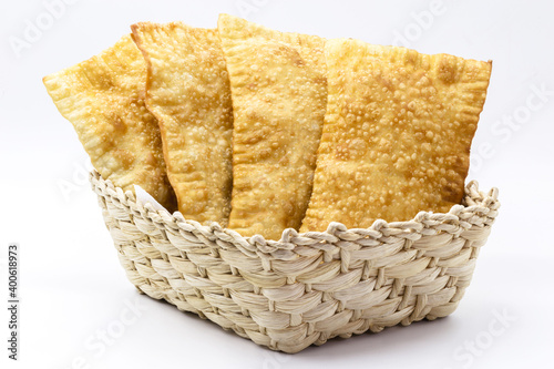 Brazilian pastry, traditional pastry called fried meat pastry, in straw basket, isolated on white background, copyspace photo