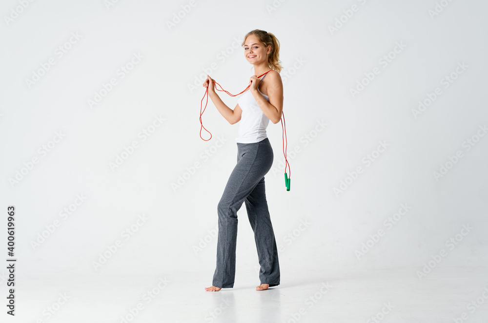 sporty woman with skipping rope and in gray fitness pants sporty woman with skipping rope and in gray fitness pants