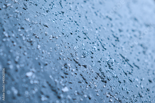 Melting snow and water drops on glass surface. Abstract blue tone background. Selective focus.