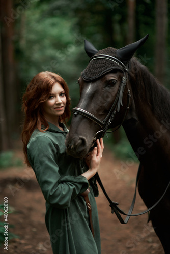 Gourmet lady in a vintage dress. A beautiful rider gently hugs the horse. Artistic Photography