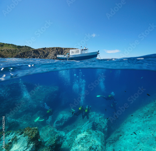 Fotografie Scuba diving, a boat on the surface and scuba divers underwater, Mediterranean s