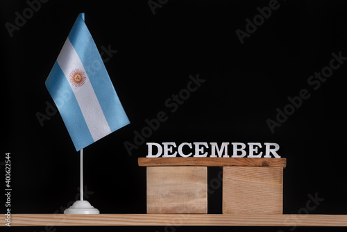 Wooden calendar of December with Argentine flag on black background. Dates of Argentina in December