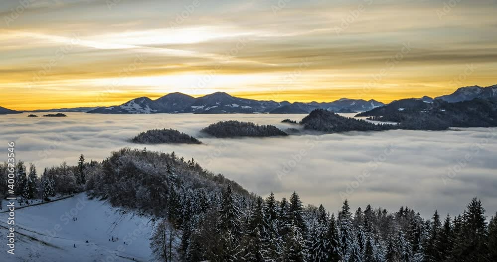 Time lapse of inversion clouds moving in valley, Slovenia. Beautiful Alps mountains covered with snow in the distance. Kids sledding on slope at sunset. Static, wide angle Time lapse of inversion clouds moving in valley, Slovenia. Beautiful Alps mountains covered with snow in the distance. Kids sledding on slope at sunset. Static, wide angle