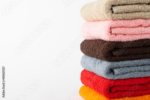 Stack of new bath towels against white background. Photo of towels with copy space