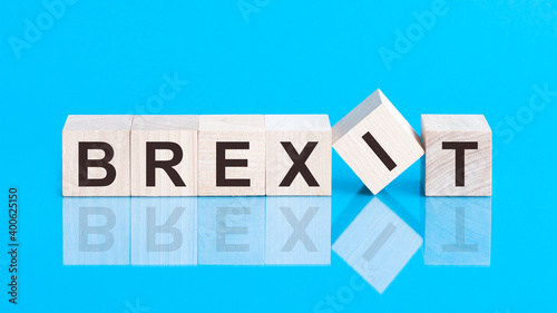 concept word forming with cube on wooden desk background - Brexit. Blue background.