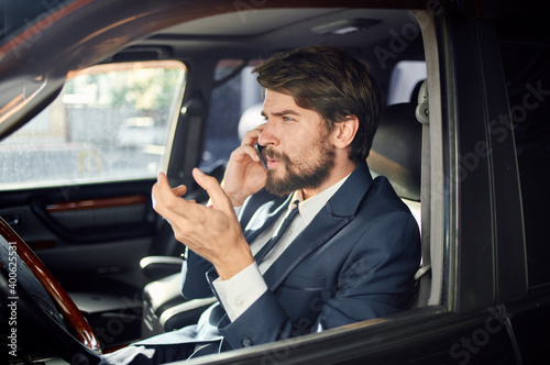 business man in a car salon talking on the phone in a suit © SHOTPRIME STUDIO