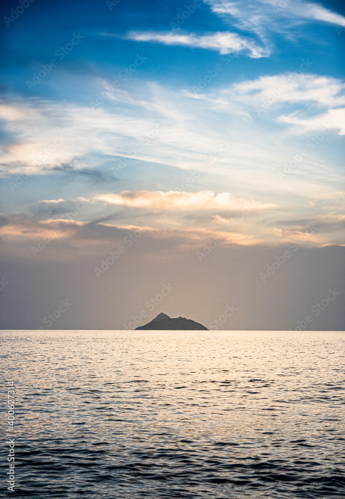 Sea with small island against cloudy sky Sea with small island against cloudy sky