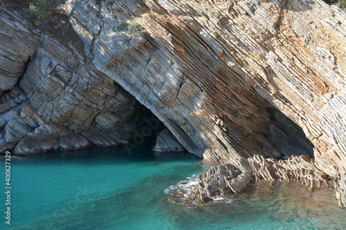 Rocks, cave and blue water. Can be used for travel agency brochures. Filmed in Petrovac, Montenegro.
