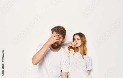 Cute young couple in white t-shirts and jeans hug emotions isolated background © SHOTPRIME STUDIO