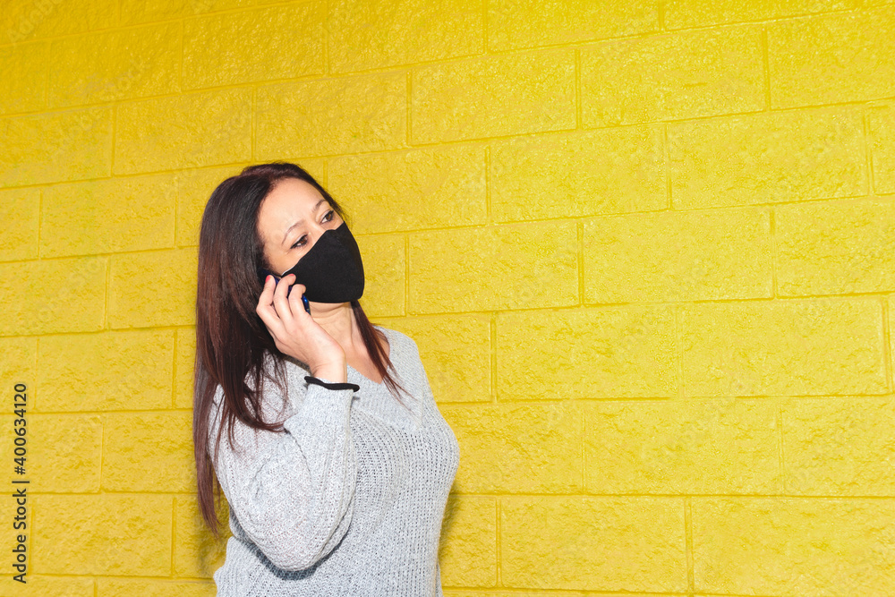 Attractive Caucasian woman has a phone conversation with the smartphone on a yellow background. Concept of progress in wireless technology. People with smartphone. Attractive Caucasian woman has a phone conversation with the smartphone on a yellow background. Concept of progress in wireless technology. People with smartphone.