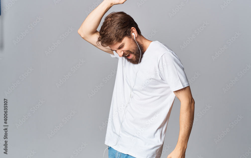 man in headphones dancing on a gray background and listening to music man in headphones dancing on a gray background and listening to music