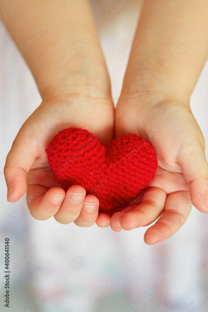 Fototapeta premium child's hands holding knitted heart