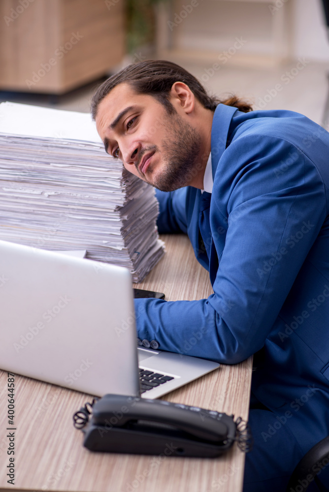 Young male employee and too much work in the office