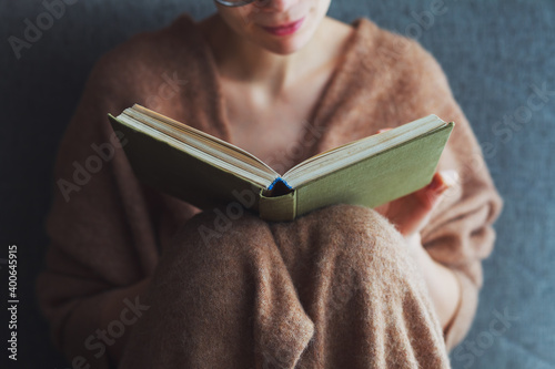 young woman reading book at home