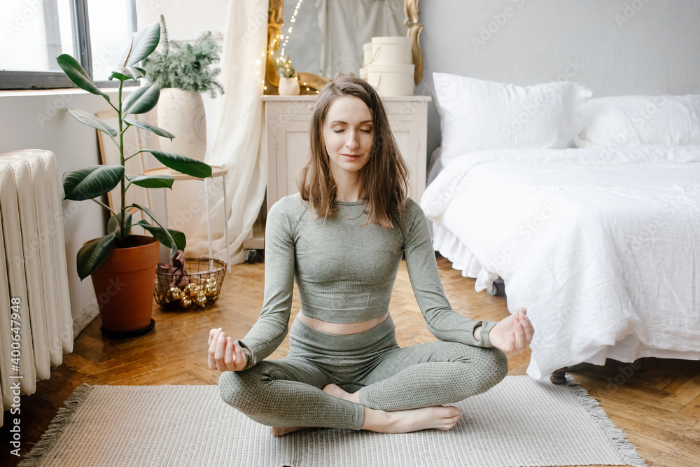 Woman practicing yoga on floor in bedroom Woman practicing yoga on floor in bedroom