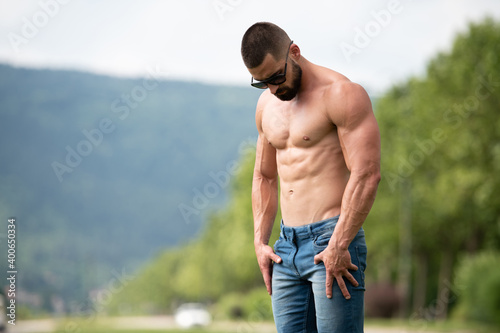 Portrait of Muscular Man Standing Strong Outdoors
