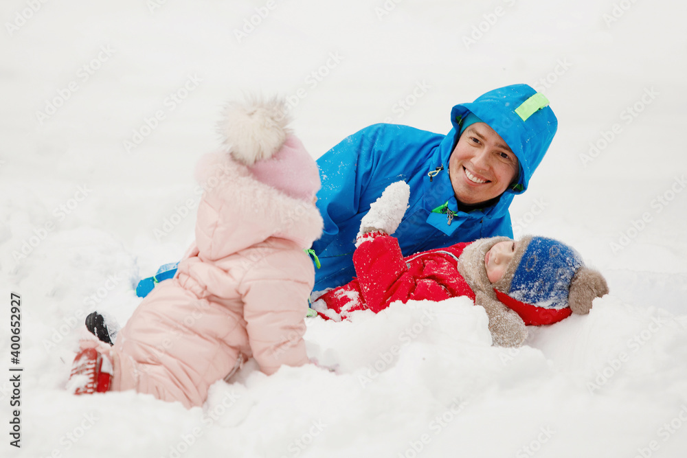 Family in winter clothes having fun, rejoice in the snow.
