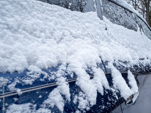 close view of blue car covered with snow in winter