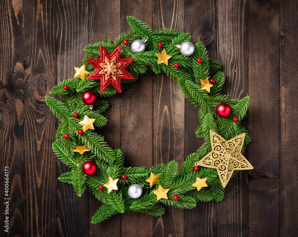 Christmas wreath with decor, Top view of tree fir spruce branches is rolled in a circle and ornament star on black table wood background, New year festive decoration concept Christmas wreath with decor, Top view of tree fir spruce branches is rolled in a circle and ornament star on black table wood background, New year festive decoration concept