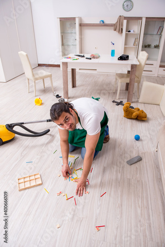 Young male contractor cleaning the flat after kids' party © Elnur