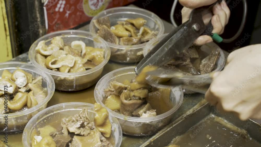 Cutting Freshly Cooked Beef Intestines And Adding To Plastic Containers For Serving - close up, high angle