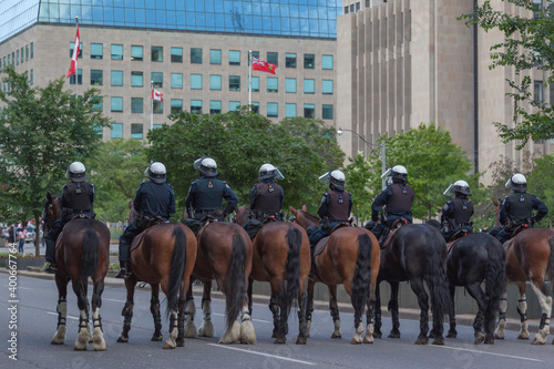 Toronto, Canada - June 24, 2017: Back of unrecognizable police officers on the horses in downtown Toronto. 