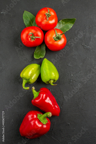 top view fresh vegetables tomatoes and bell-peppers on dark background salad ripe meal color