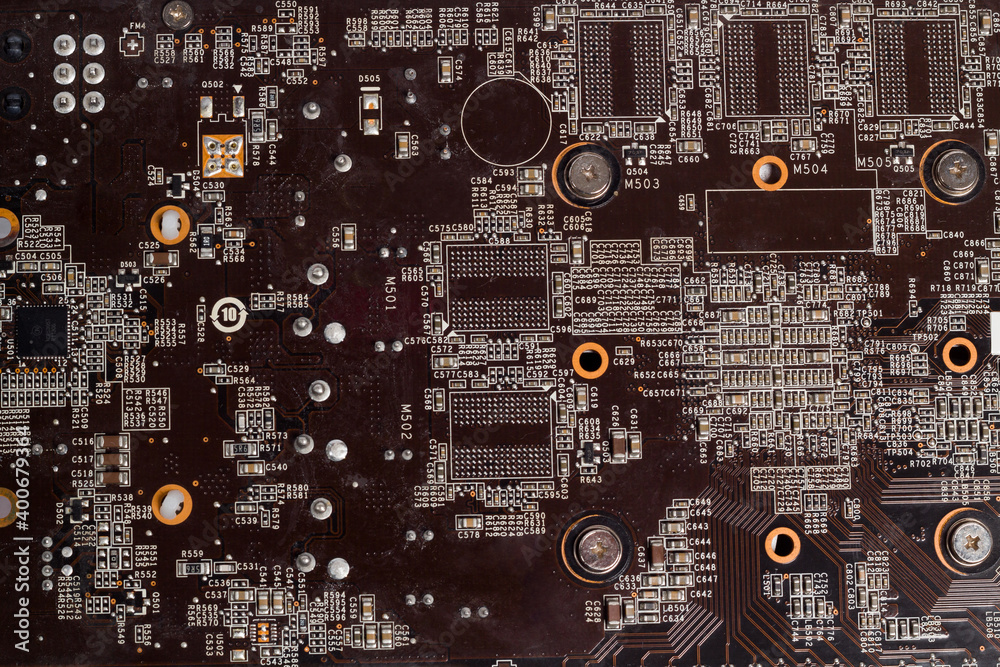 Obraz premium Fragment and components of a motherboard (PCB) of computer technology with many elements. Macro photography of processors and transistors. IT industry background