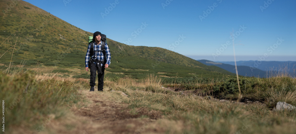 Man Traveler with backpack mountaineering Travel Lifestyle concept mountains on background Summer expedition vacations
