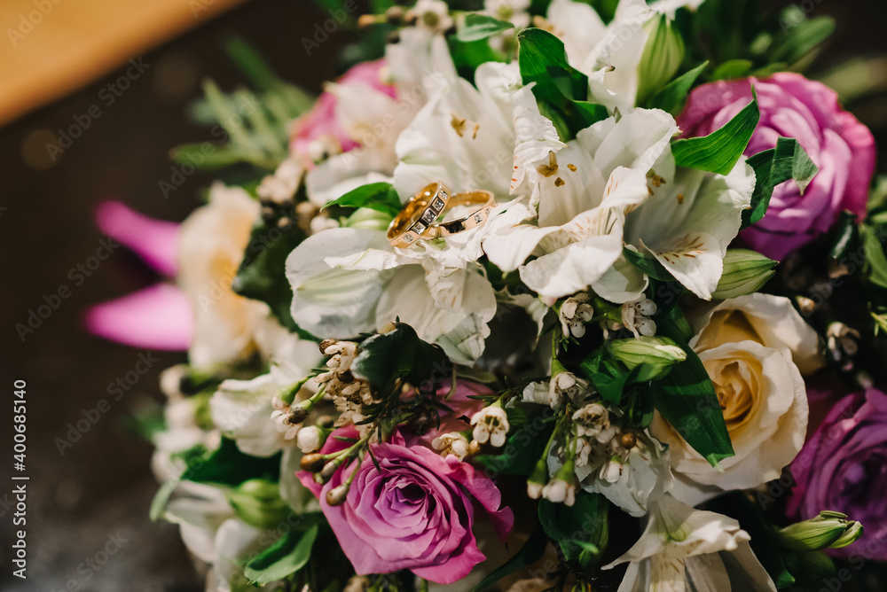 two gold wedding rings with diamonds lie on bouquet two gold wedding rings with diamonds lie on bouquet