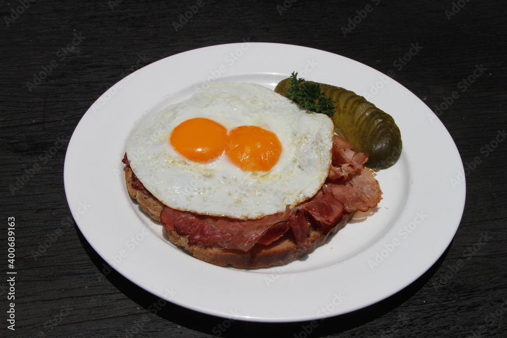 Famous German meal called Strammer Max. Fried eggs and ham on sourdough bread, served with gherkins Famous German meal called Strammer Max. Fried eggs and ham on sourdough bread, served with gherkins