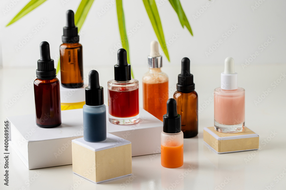 Bio serum, natural oil and cream on the podium at white background with plant leaf. Natural cosmetic for perfect skin care concept. Bio serum, natural oil and cream on the podium at white background with plant leaf. Natural cosmetic for perfect skin care concept.