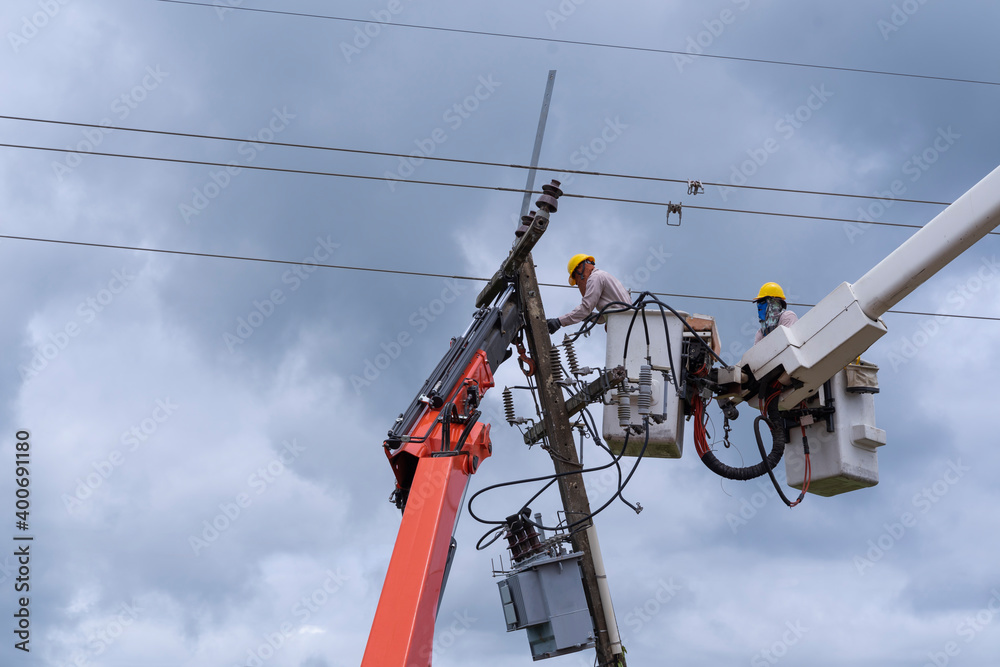 electrician works on bucket car to maintain high voltage transmission lines. electrician works on bucket car to maintain high voltage transmission lines.