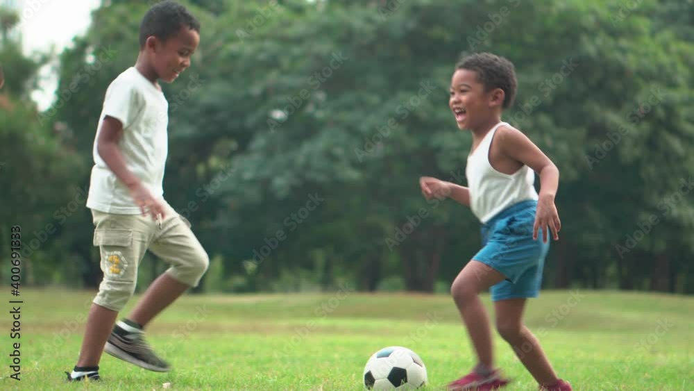 Cheerful african american father and two sons playing with football in park, Happiness family concepts
Cheerful african american father and two sons playing with football in park, Happiness family concepts