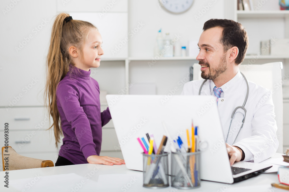 Fototapeta premium Young female visitor consulting smiling man doctor in hospital