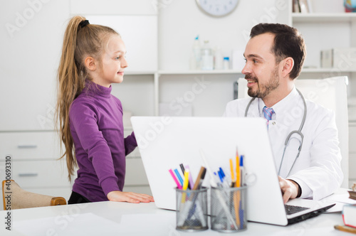 Young female visitor consulting smiling man doctor in hospital © JackF