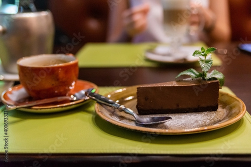 Piece of chocolate cheesecake with berries on dark background, close up photo