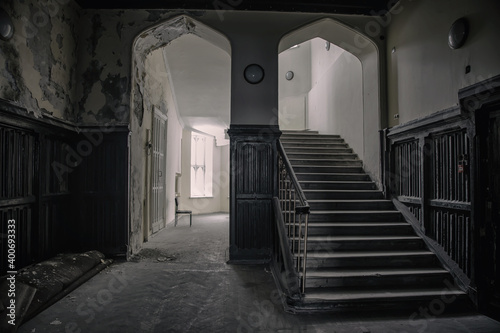 A beautiful hall with a staircase in an old abandoned house. An old abandoned manor. Gothic architecture. Ancient staircase.