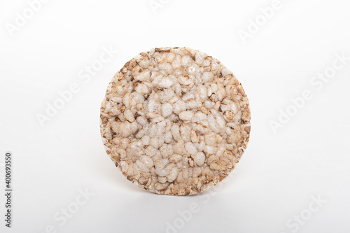 Round slice of airy crispy buckwheat rice bread loaf isolated on white.