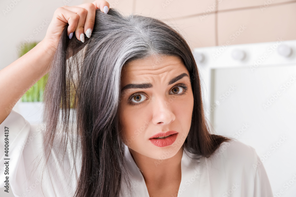 Naklejka premium Stressed woman with graying hair at home