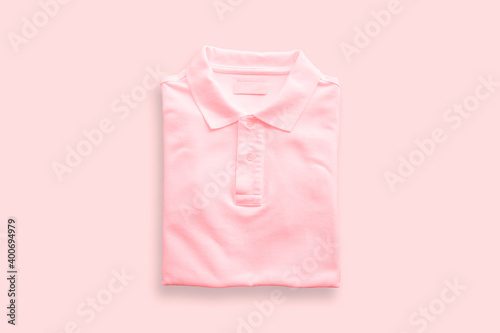 Top view of pink polo t-shirt on pink floor background.