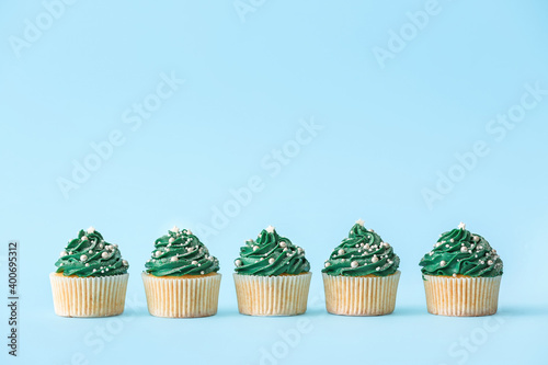 Fototapeta Naklejka Na Ścianę i Meble -  Tasty Christmas cupcakes on color background